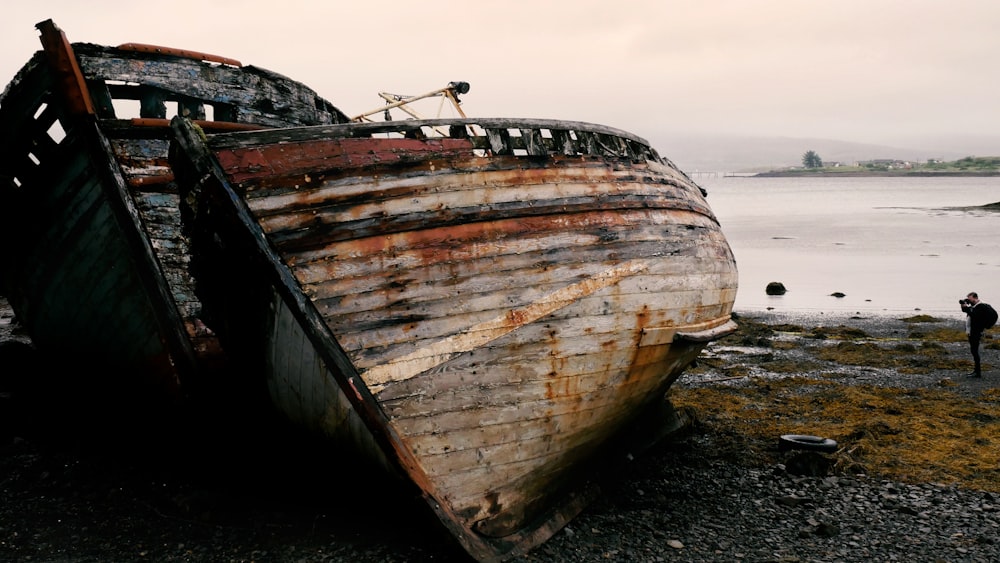 brown and white boat on black sand during daytime