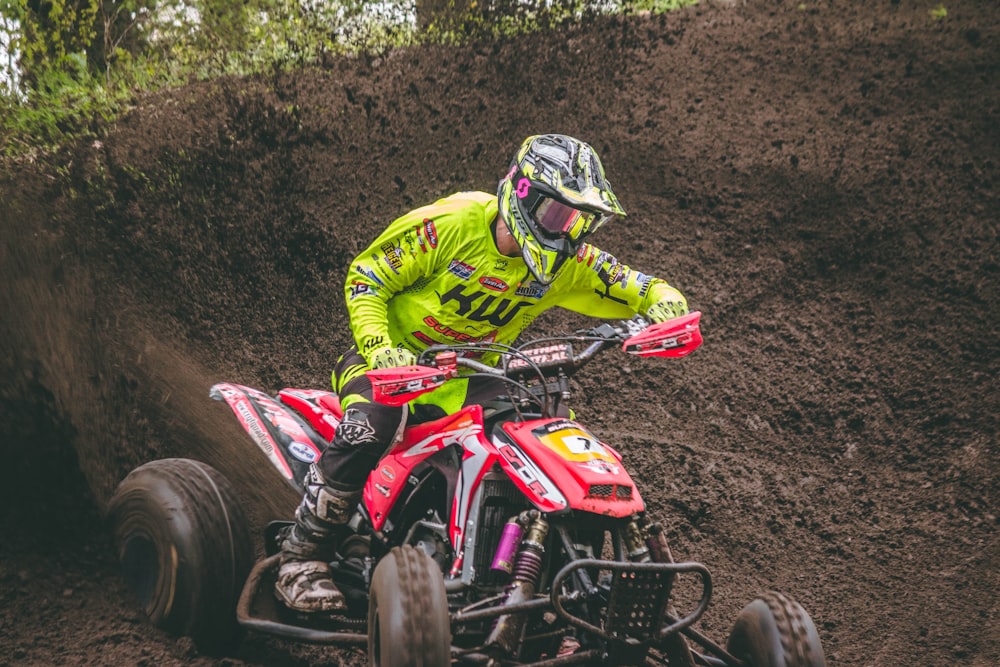 man riding red ATV on ground