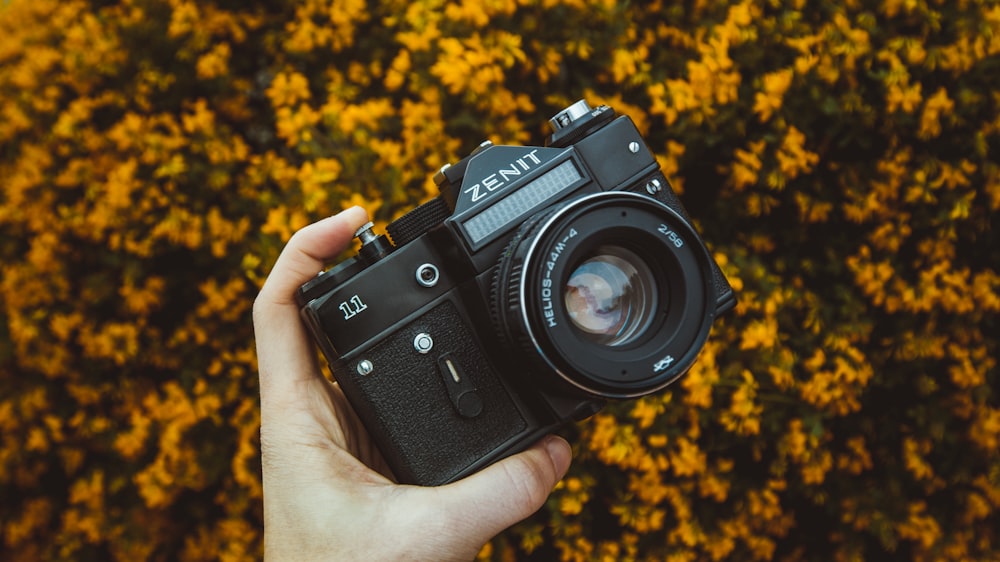 person holding black Zenit camera