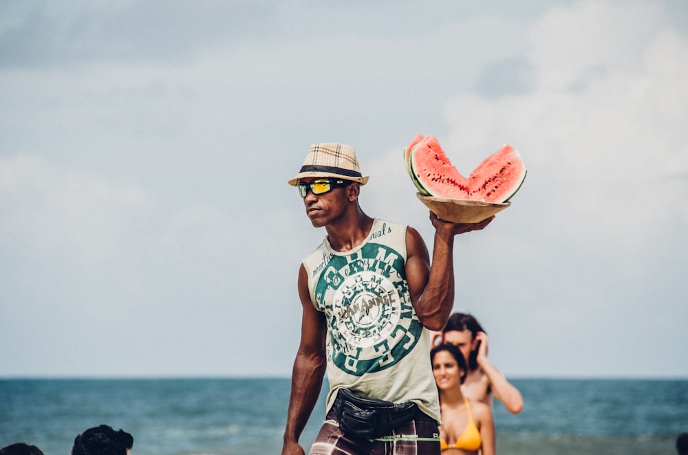 man holding sliced watermelons