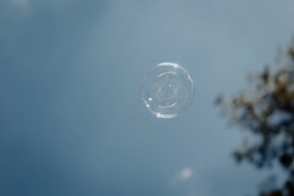 A delicate soap bubble floating against a soft pastel background, evoking 'L’amour est une bulle de savon.'