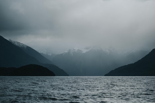 fog-covered mountain near body of water in Lake Te Anau New Zealand