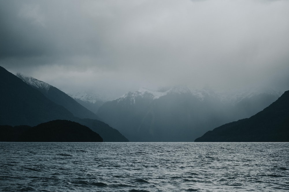 fog-covered mountain near body of water