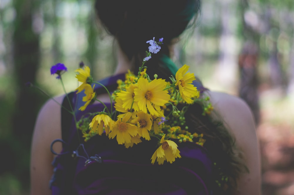 person wearing backpack with yellow petaled flower