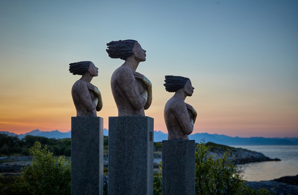 três estátuas de concreto