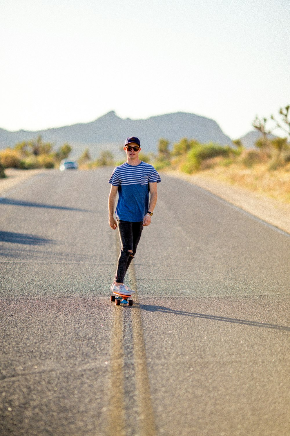 Homem andando de skate na estrada cinza durante o dia