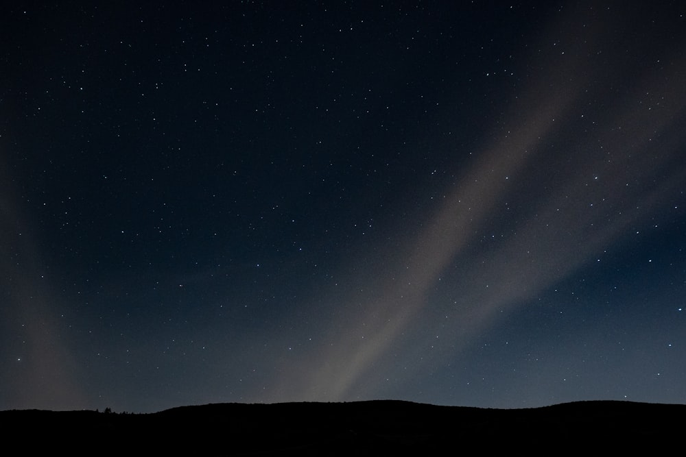 silhouette of mountain under starry night