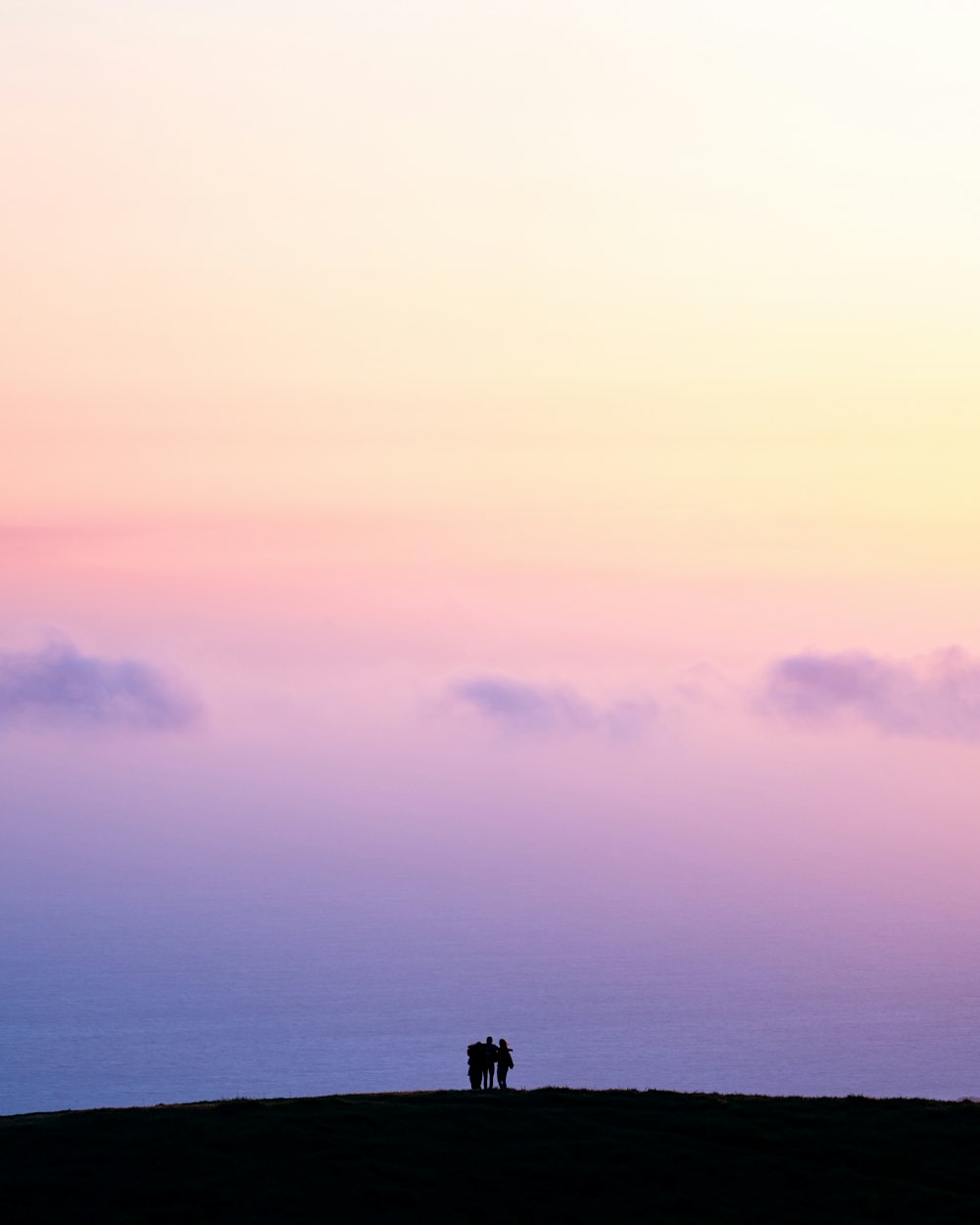 silhouette of three people holding each other