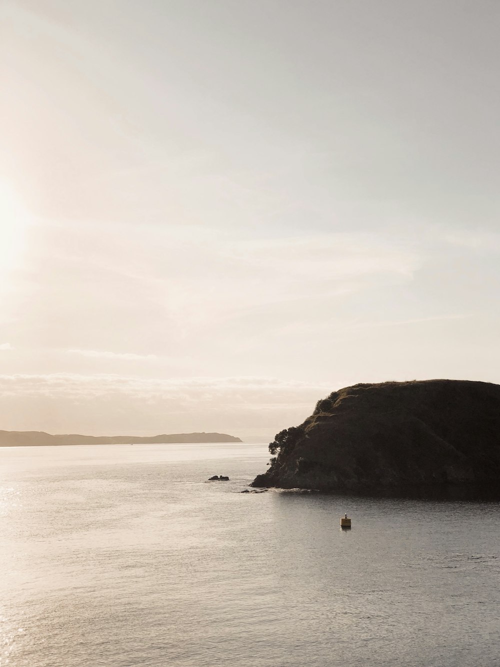 boat sailing near rock of ocean