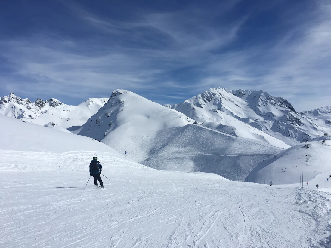 Skiër op een piste bij Les Menuires met uitzicht over de bergen