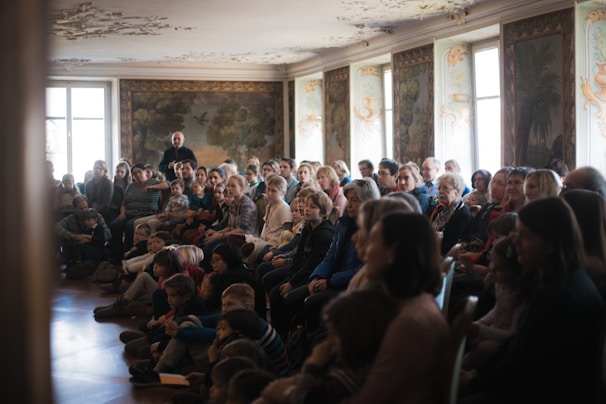 A warm, softly lit classroom with parents attentively listening to a positive discipline instructor.