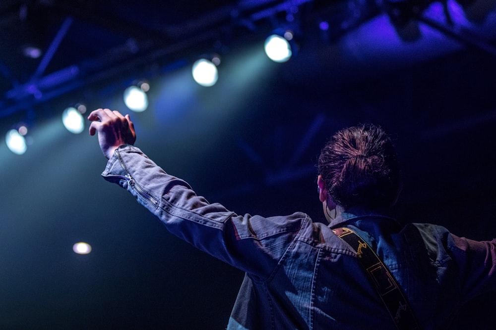 selective focus photography of person on stage with lights