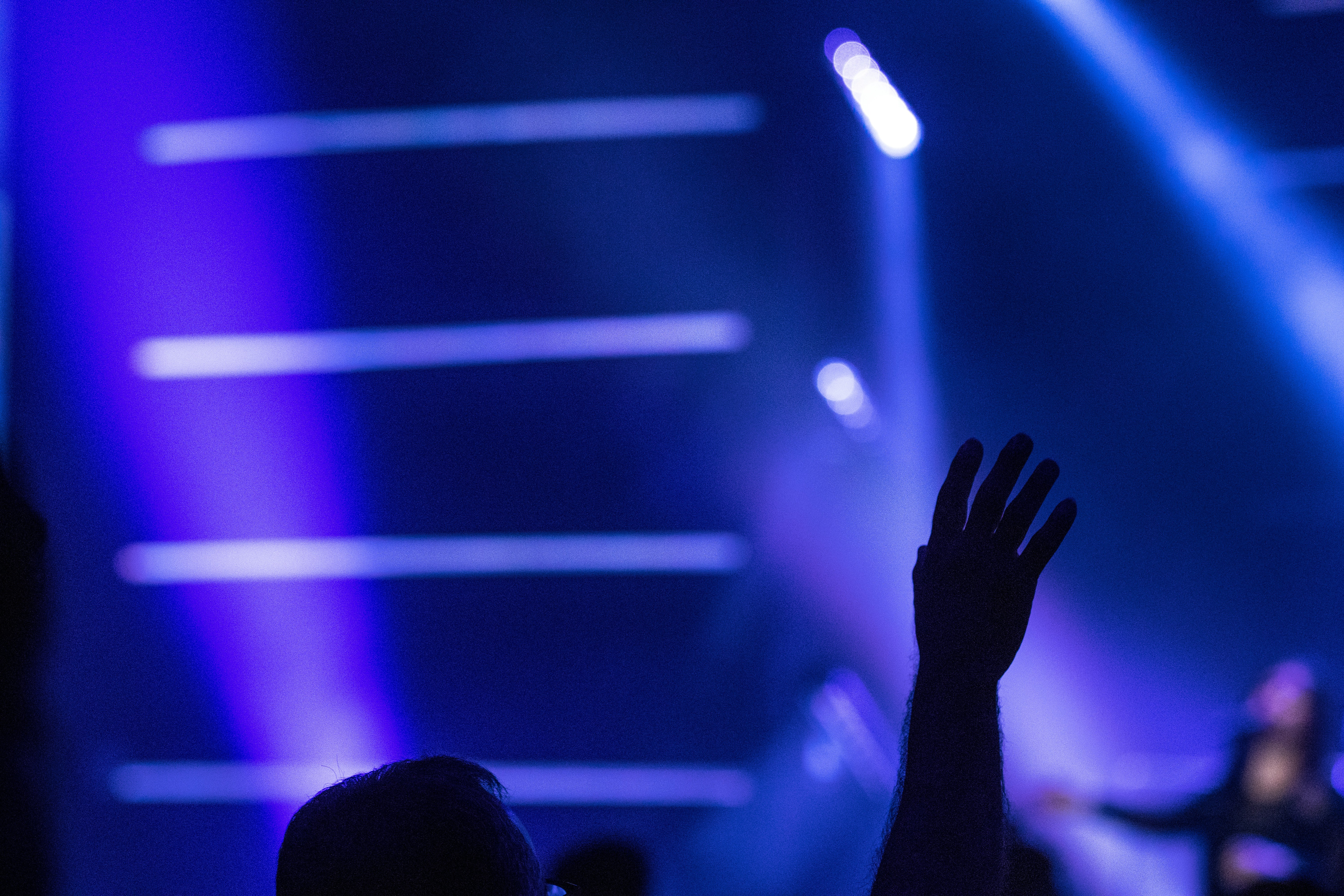 silhouette of person raising hands inside stadium
