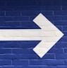 white arrow painted on brick wall