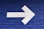 white arrow painted on brick wall