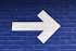 white arrow painted on brick wall