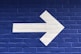white arrow painted on brick wall
