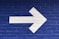 white arrow painted on brick wall