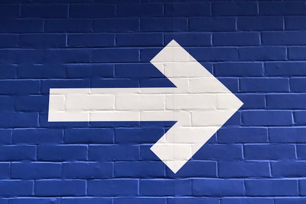white arrow pointing right on a dark blue background