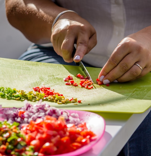 person slicing species on green chopping board