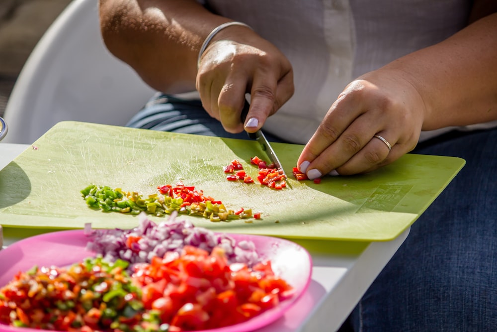 persona che affetta le specie sul tagliere verde