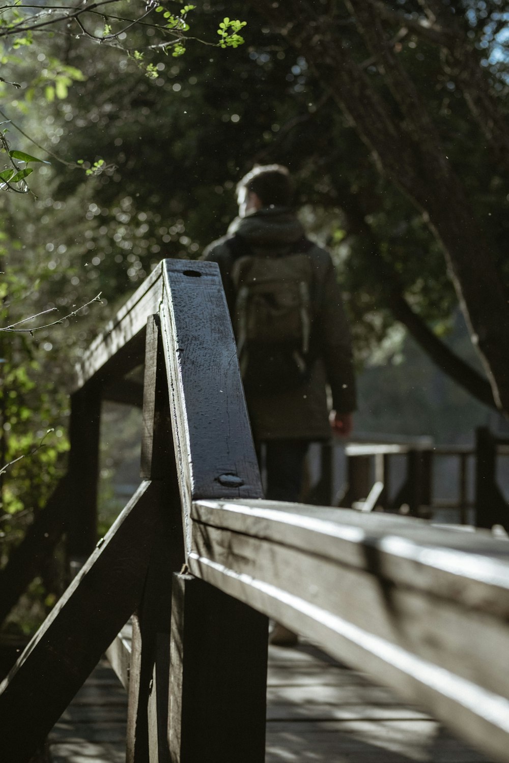 man standing on brown wooden bridge during daytime