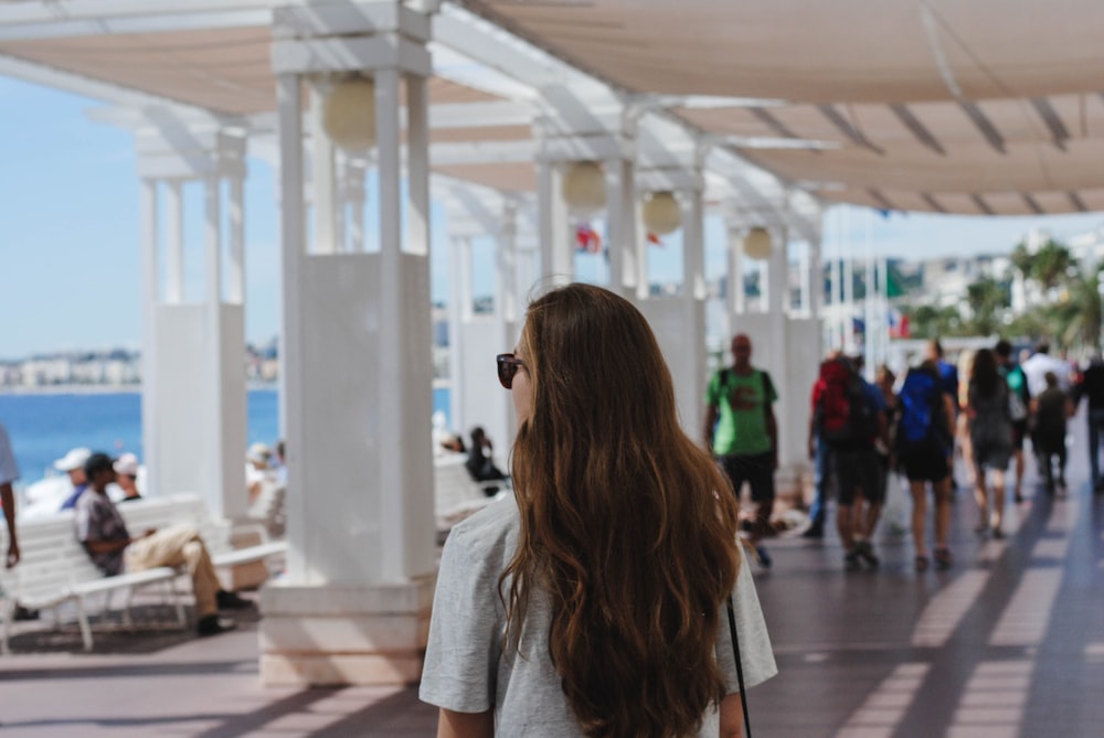 woman standing near white concrete post