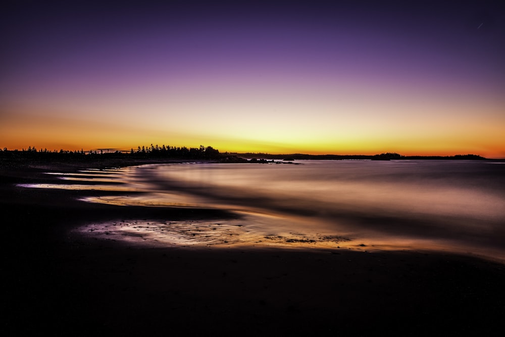 silhouette of body of water during golden hour