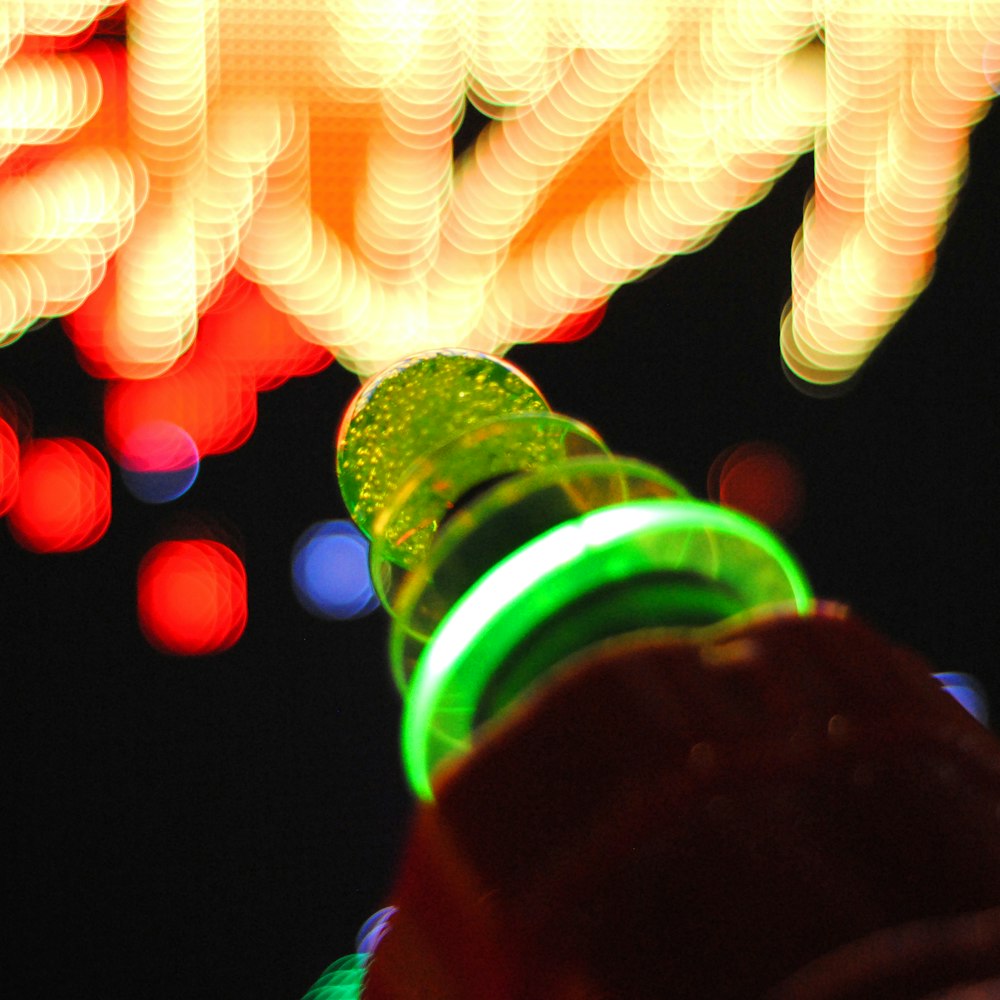 person holding green glass bottle