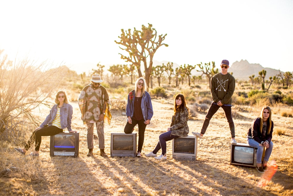 group of six people standing on desert