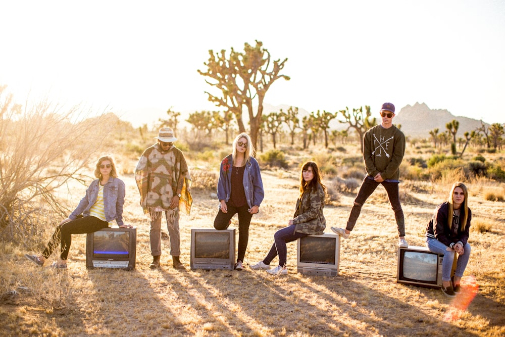 Grupo de seis pessoas em pé no deserto