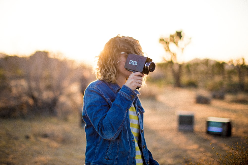 person using video camera during daytime