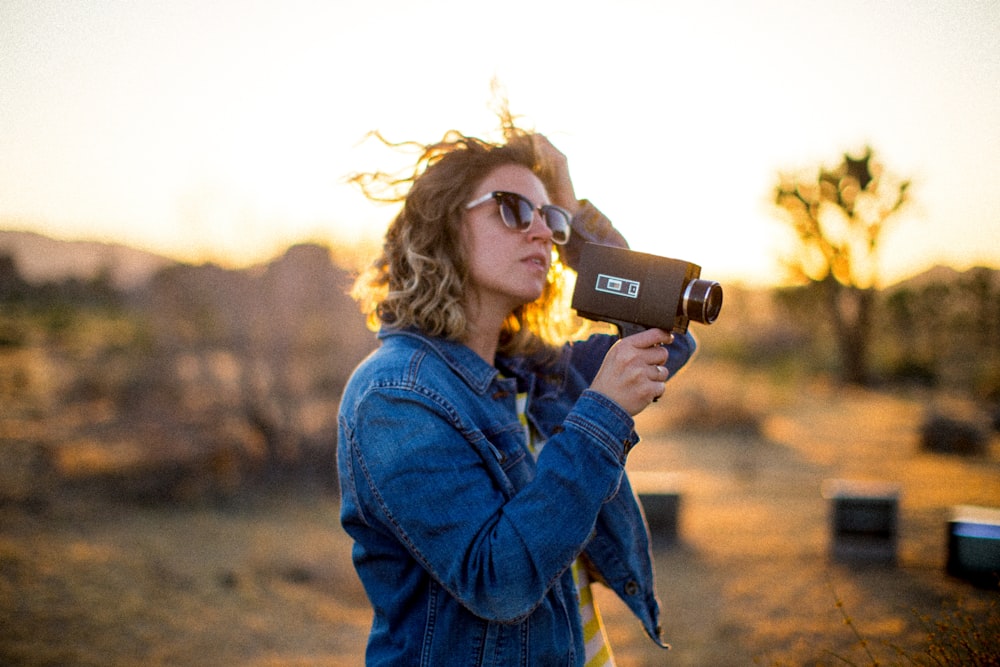 Mujer sosteniendo la cámara durante la hora dorada