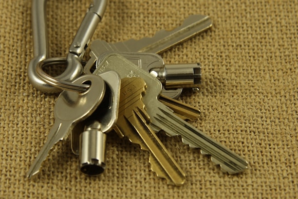 Close-up of heavy equipment ignition keys hanging on a metal hook.