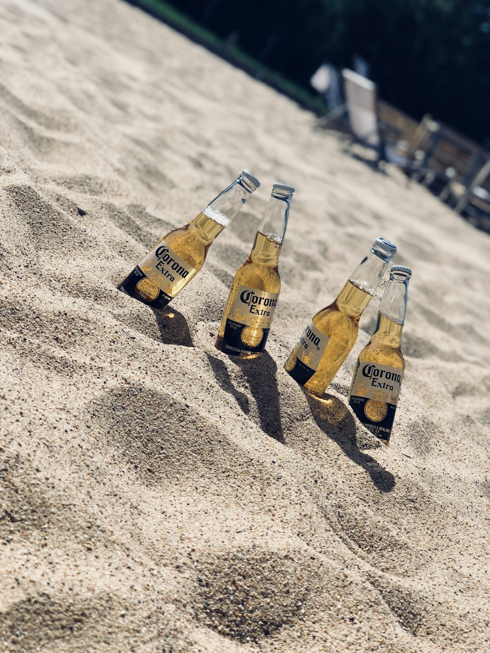 four Corona Extra beer bottles in sand