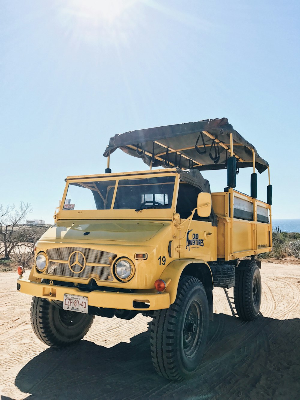 yellow Mercedes-Benz truck on field