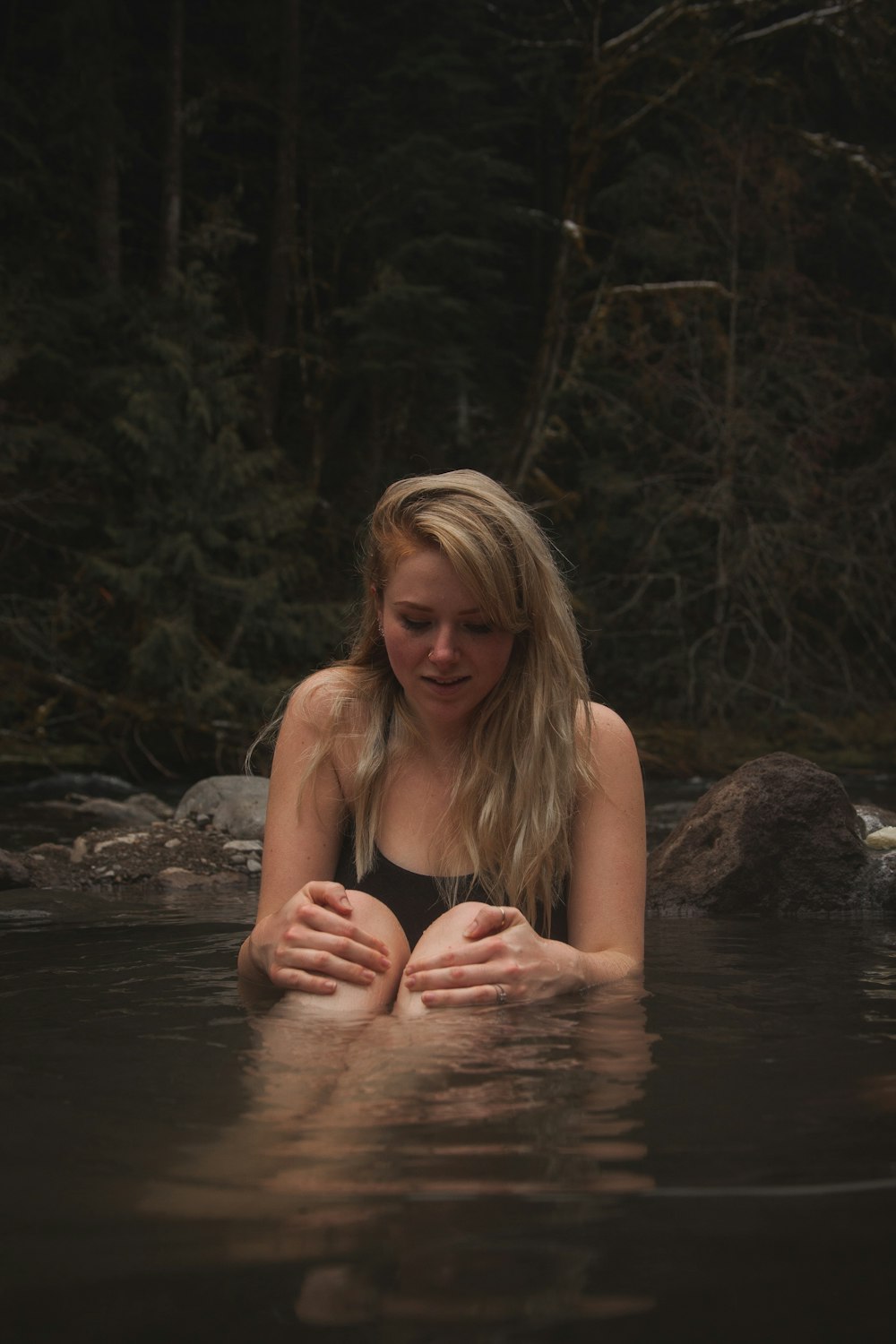 woman in body of water near trees