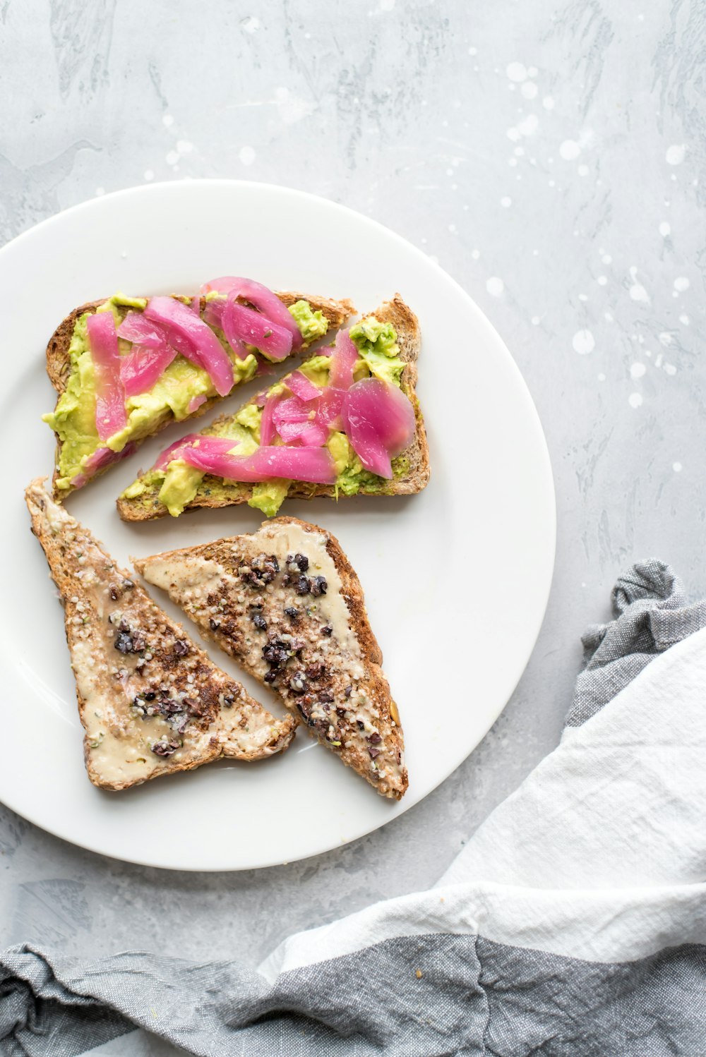 two vegetable sandwiches on white plate