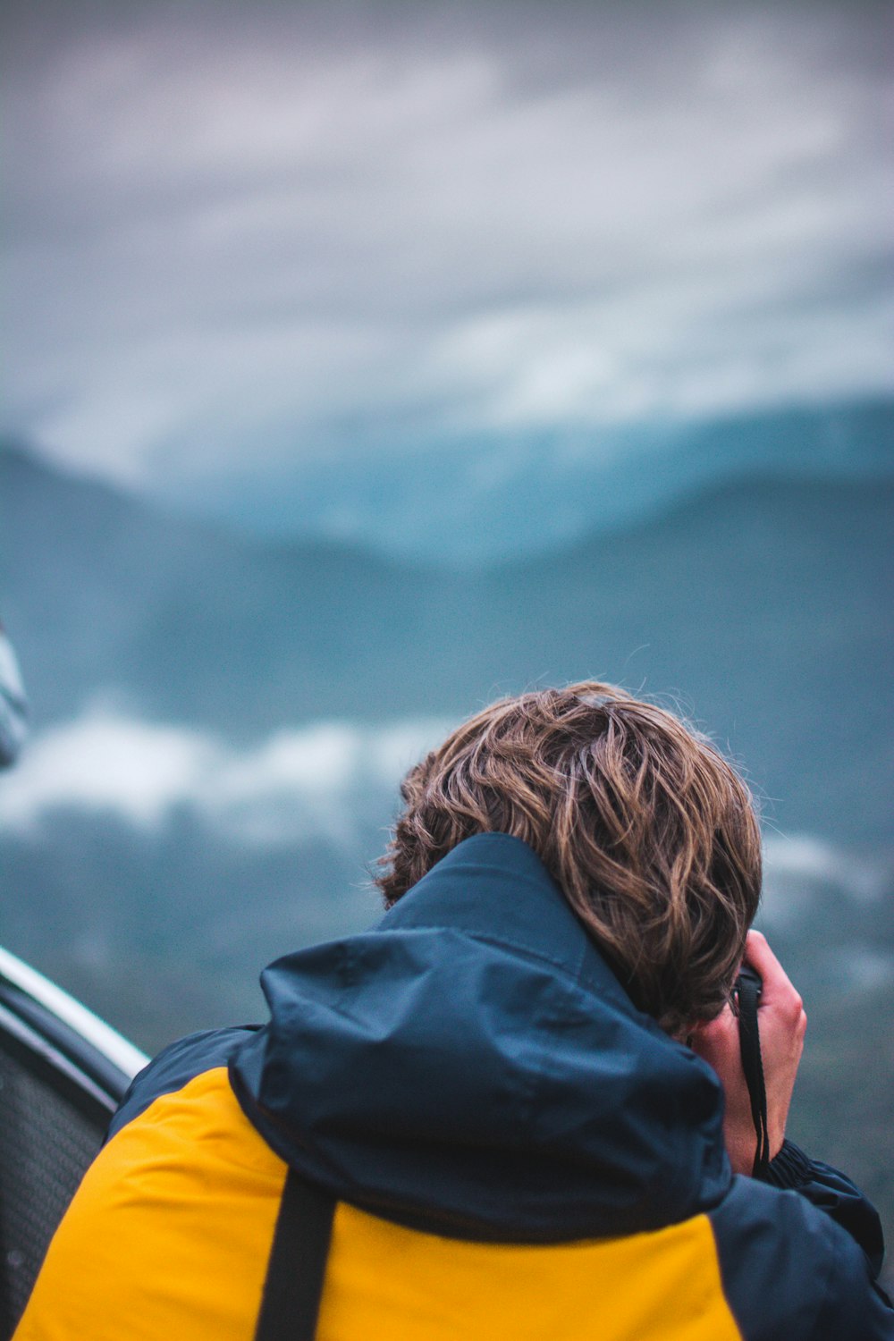 Fotografia de foco seletivo de pessoa tirando foto da montanha durante o dia