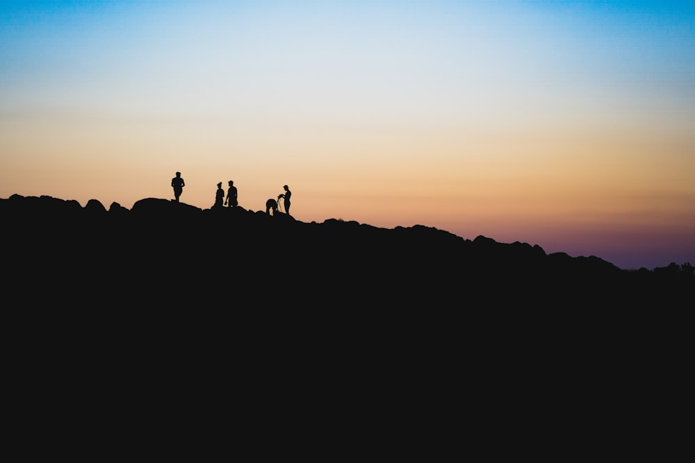 silhouette of people on a mountain