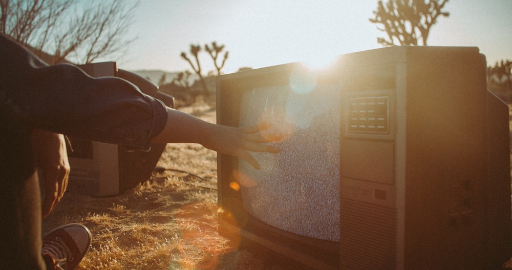 person touching CRT TV screen