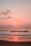 A serene beach view with gentle waves lapping against the shore at sunset.