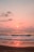 A serene beach view with gentle waves lapping against the shore at sunset.