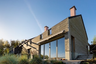 gray and white wooden house under blue sky during daytime