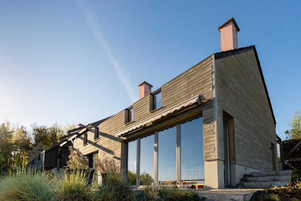 Casa de madera gris y blanca bajo el cielo azul durante el día