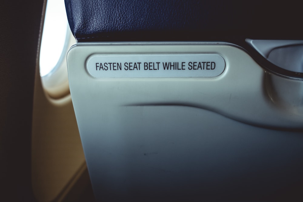 a seat with a sign that says fasten seat belt while seated