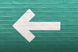selective focus photography of white arrow signage