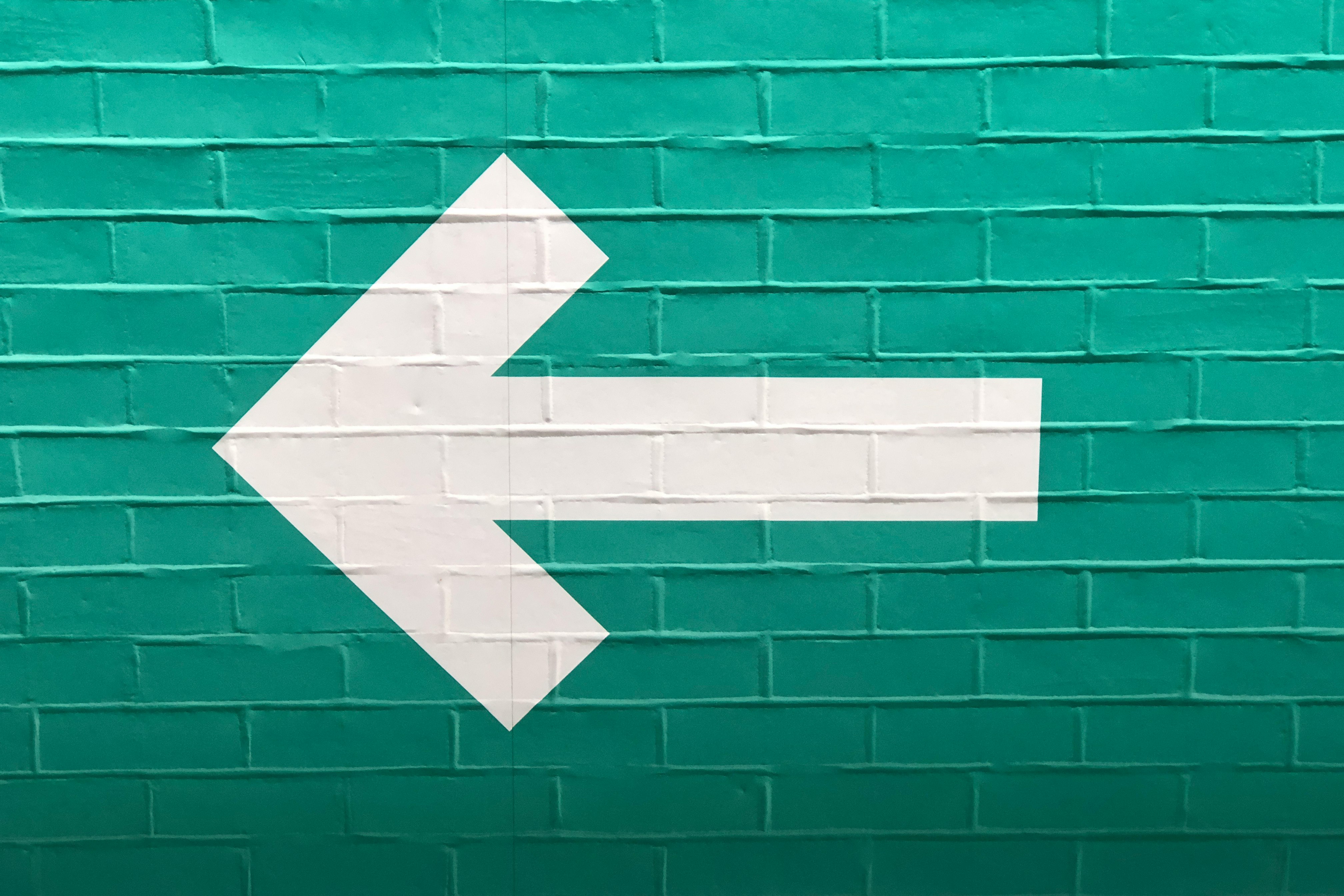Further to me posting a white arrow on a blue wall, pointing right, here is the other, a white arrow on a green wall, pointing left.