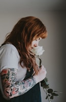 man smelling white rose flower
