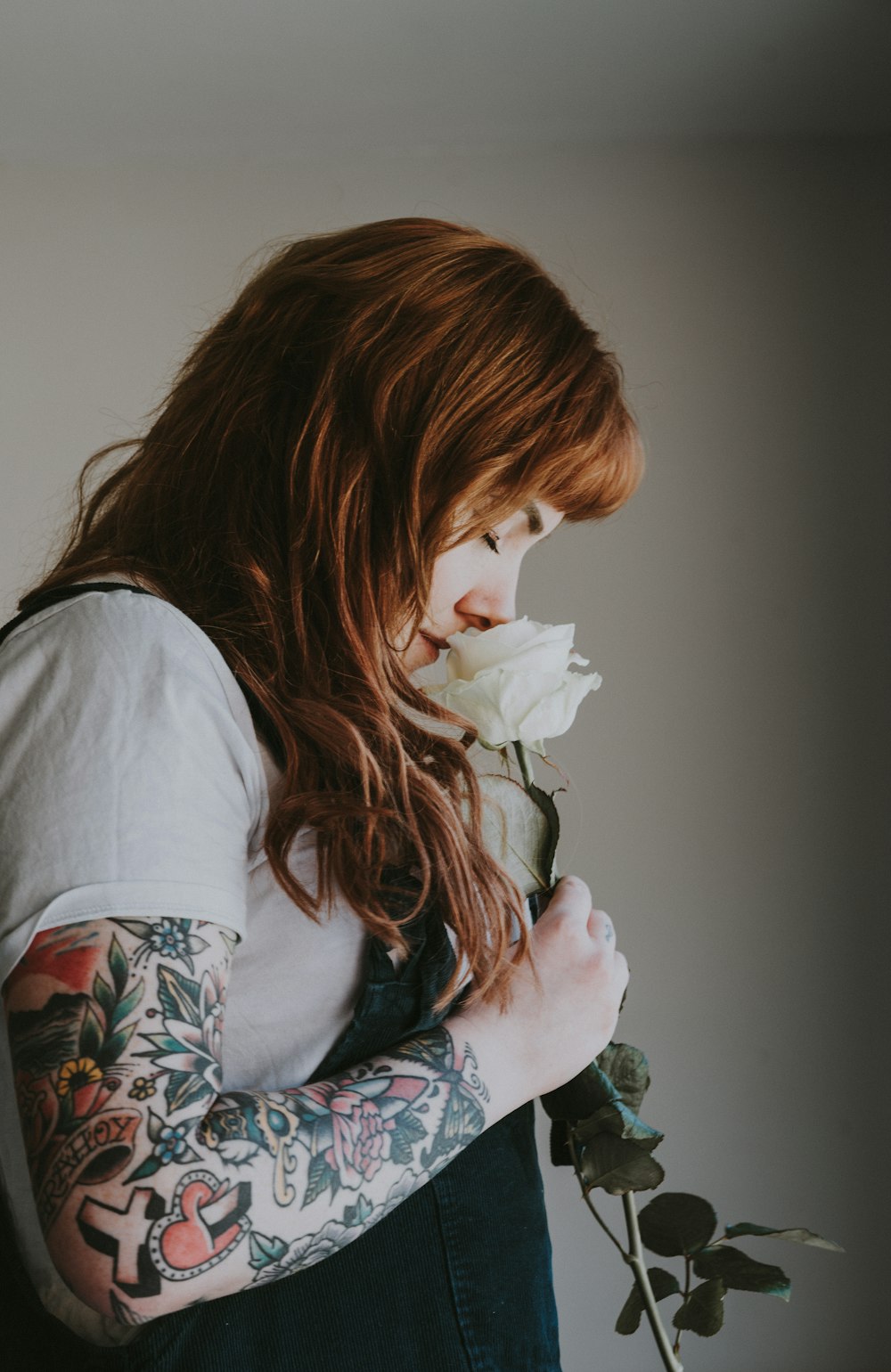 man smelling white rose flower